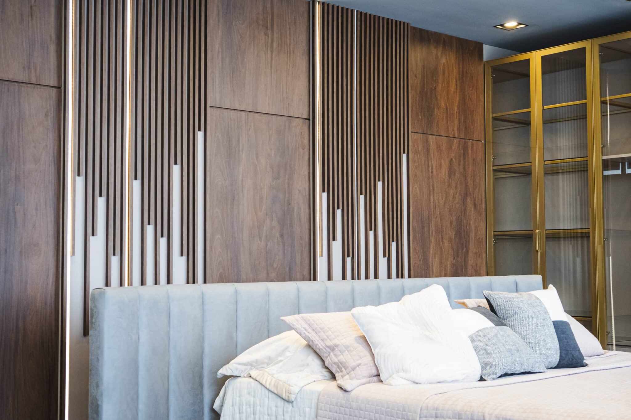 Painel ripado madeira com guarda-roupa dourado — showroom Meu Planejado Online